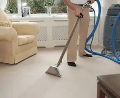 Carpet cleaning professional removing dirt and stains with a hot-water extraction tool in a home, Glendale, AZ.